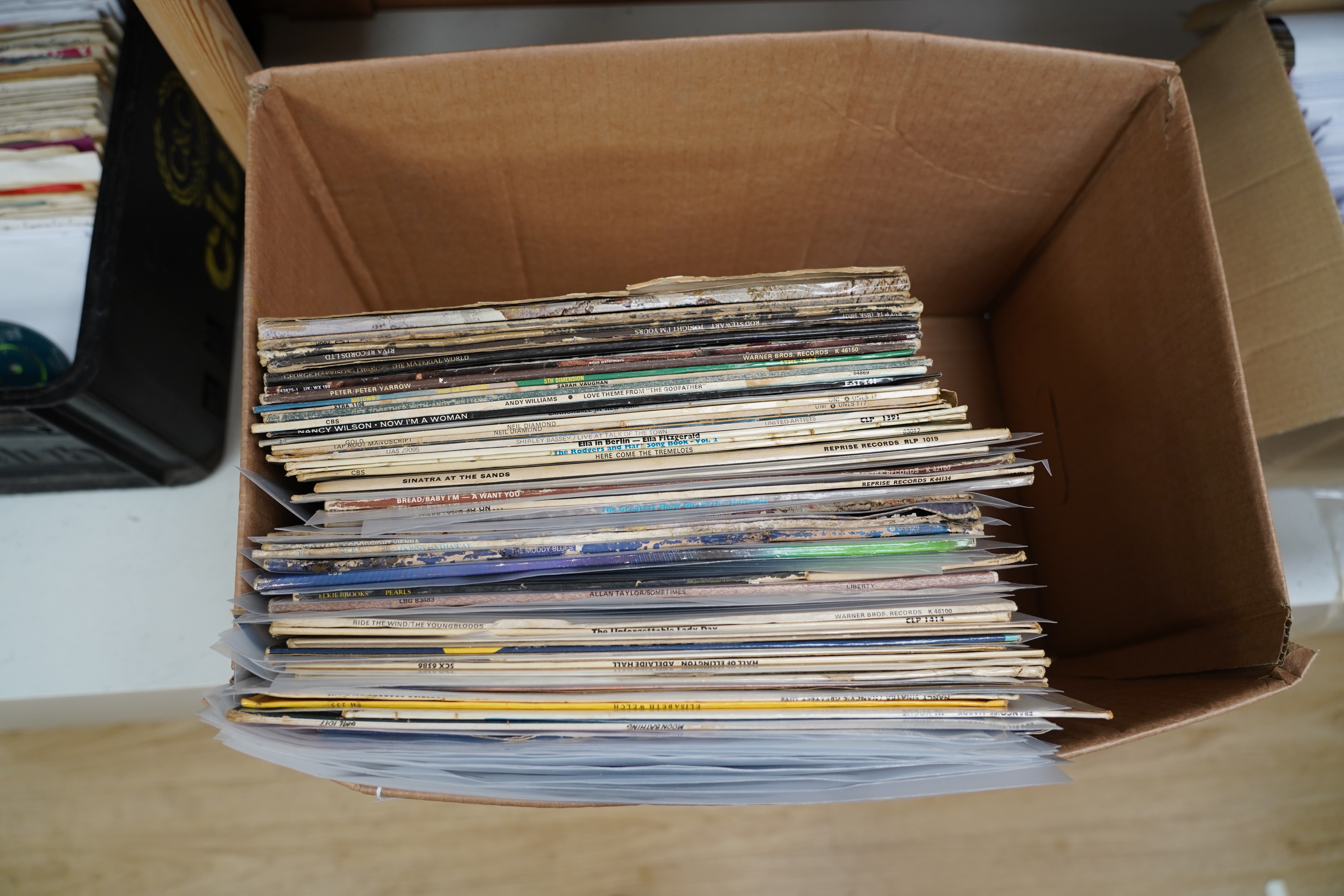 A box of LP record albums, artist including; Neil Diamond, Shirley Bassey, Ella Fitzgerald, Billie Holiday, Ringo Starr, Dionne Warwick, etc., many LPs missing covers or with only the remains of covers, some covers witho